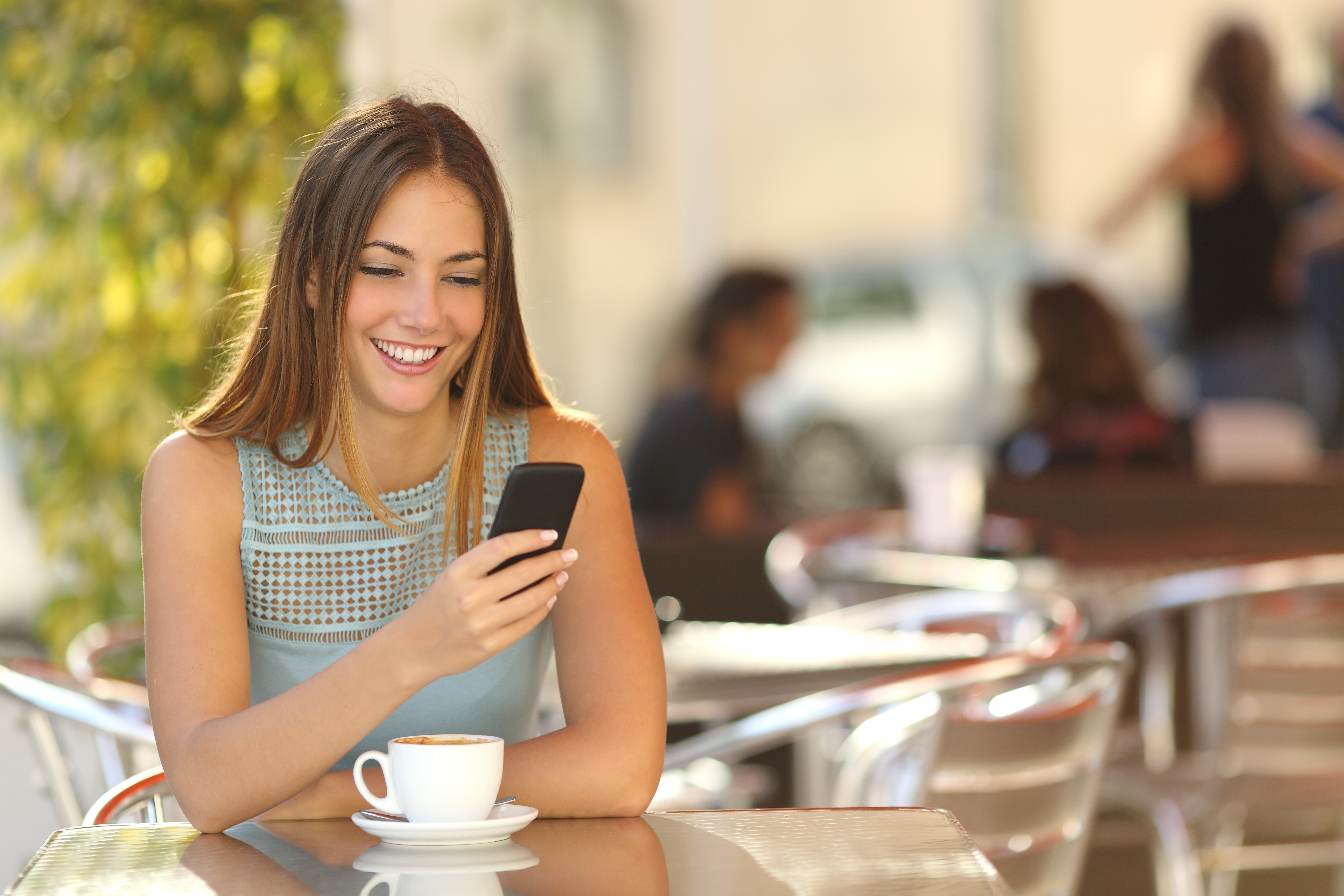 girl on cell phone at cafe looking at high SEO content