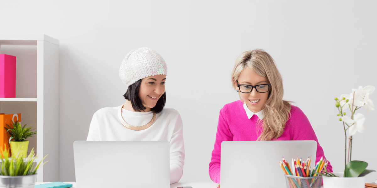 two women working with laptops